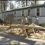 Volunteers build a ram on to a mobile home to make it accessible.